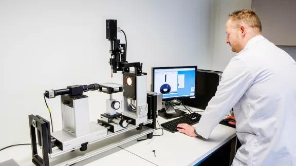 A lab technician analyzes a liquid droplet's contact angle using a DataPhysics measurement system and software