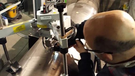 A technician operates a portable X-ray diffraction device to measure residual stress directly on an installed metal component on-site