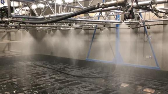 A multi-nozzle ice spray array creates a fine mist inside the large climate chamber to simulate icing conditions