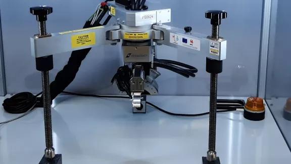 Close-up of a portable Stresstech X-ray diffraction sensor used for residual stress measurement, with a radiation warning label