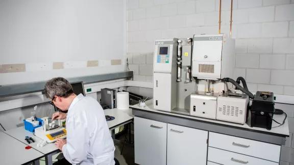 Sirris technician weighing a sample on a precision balance before carbon and sulphur analysis.