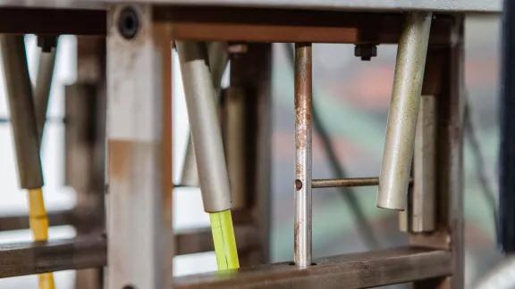 Close-up of the loading mechanism and calibrated rulers on an HDT and Vicat testing apparatus