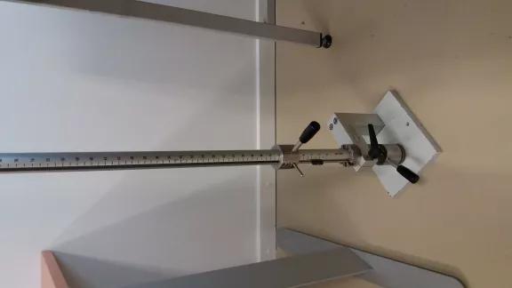 Vertical impact tester on a bench plate with a graduated scale in kilogram centimetre for reading absorbed energy