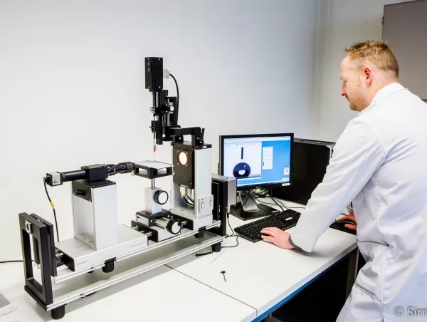 A lab technician analyzes a liquid droplet's contact angle using a DataPhysics measurement system and software