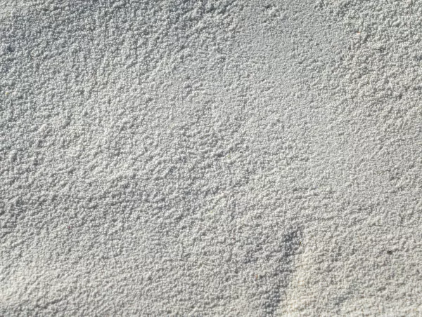 Close-up of a fine white granular powder, representative of samples used in gas pycnometry density testing