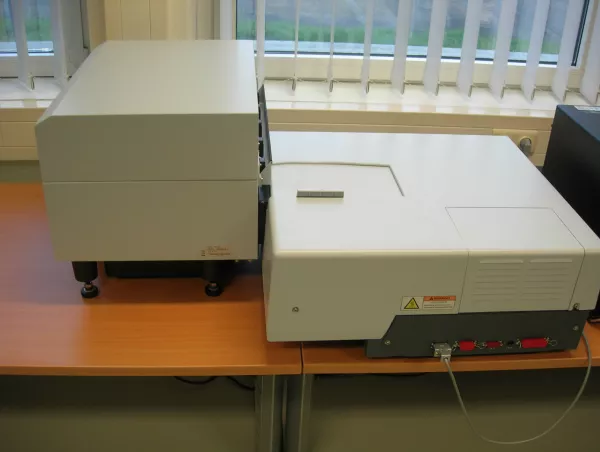 UV-VIS spectrophotometer with an integrating sphere module on a laboratory bench, used to measure reflection and transmission across wavelengths