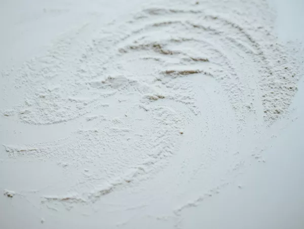 Close-up of fine powder with swirling surface patterns, representative of the flow behaviour analyzed in GranuDrum testing
