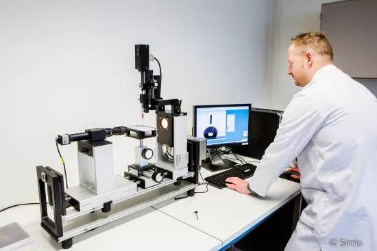 A lab technician analyzes a liquid droplet's contact angle using a DataPhysics measurement system and software